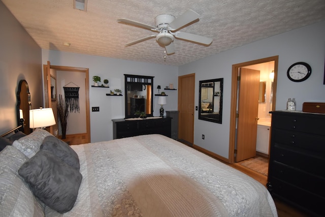 bedroom featuring a ceiling fan, wood finished floors, baseboards, and a textured ceiling