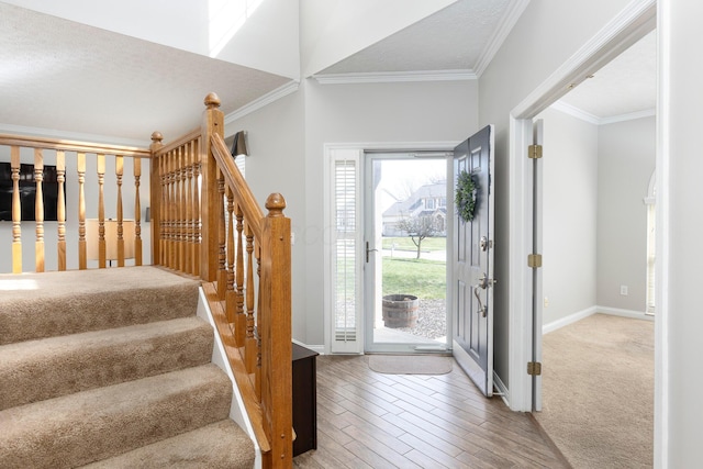foyer featuring crown molding, baseboards, and wood finished floors