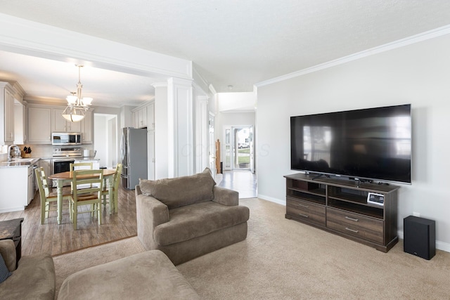 living area featuring baseboards, crown molding, a notable chandelier, and light carpet
