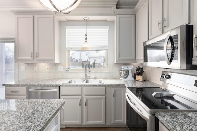 kitchen with stainless steel appliances, decorative backsplash, a sink, light stone counters, and pendant lighting