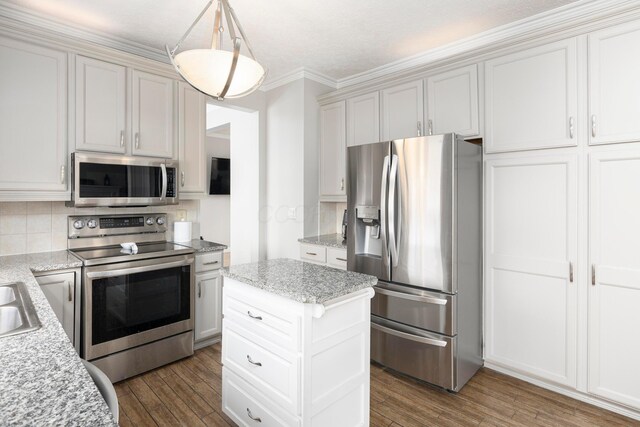kitchen with a sink, wood finished floors, decorative backsplash, and appliances with stainless steel finishes