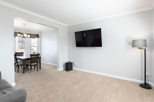 living area with a notable chandelier, carpet, baseboards, and crown molding