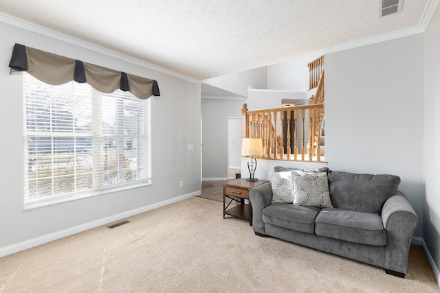 carpeted living area with visible vents, crown molding, and a textured ceiling