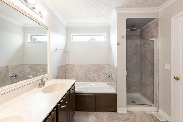 bathroom featuring a sink, a garden tub, a shower stall, a textured ceiling, and double vanity
