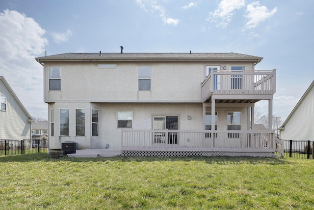 rear view of house with fence, central air condition unit, and a yard