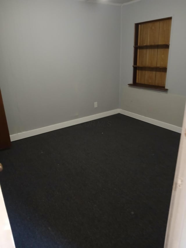 unfurnished room with baseboards