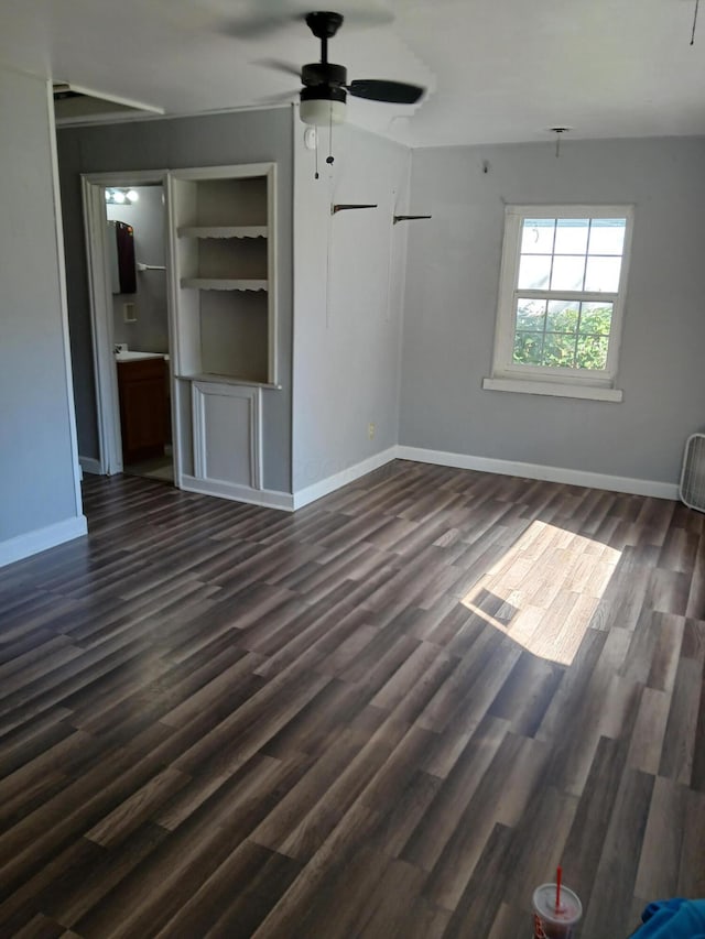 unfurnished living room with dark wood-type flooring, a ceiling fan, visible vents, and baseboards