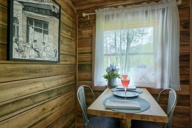 dining space featuring wood walls