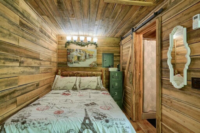 bedroom featuring wood ceiling, wood walls, and a barn door