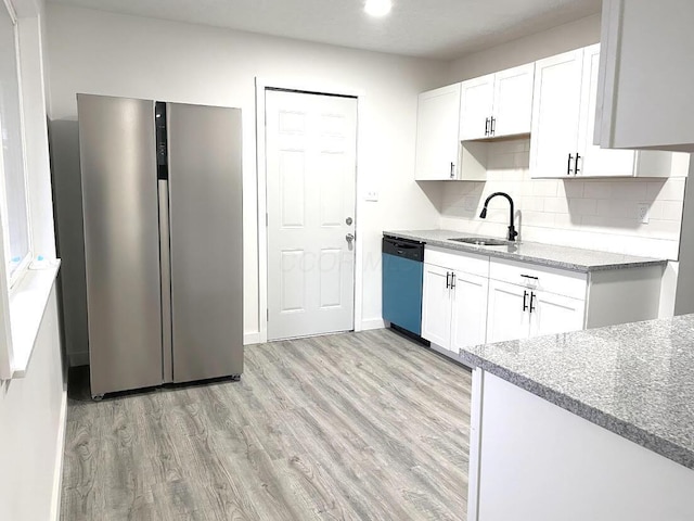 1616 Koebel Rd, Columbus, OH 43207 - kitchen featuring light stone countertops, freestanding refrigerator, a sink, dishwasher, and light wood-type flooring