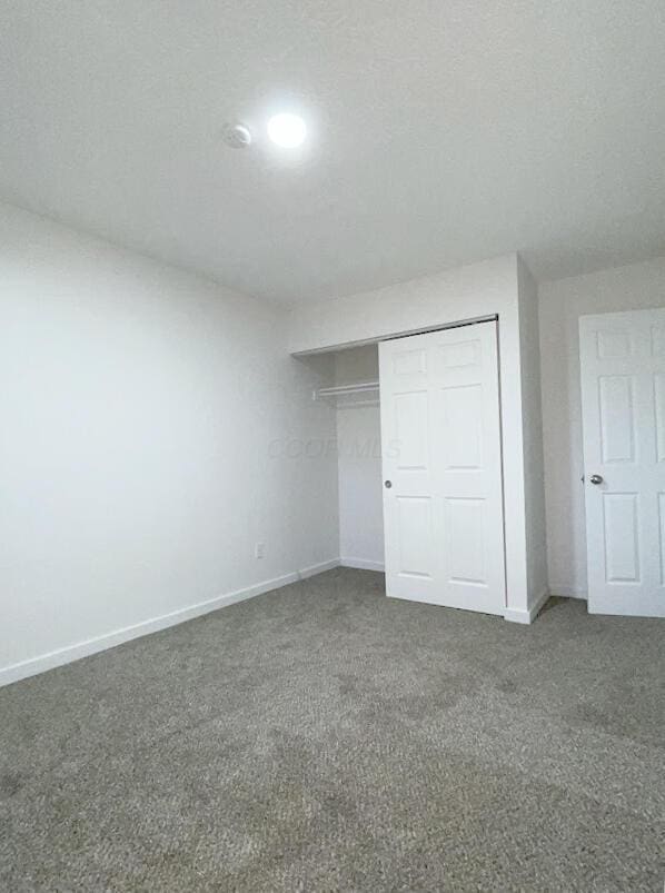 1616 Koebel Rd, Columbus, OH 43207 - unfurnished bedroom featuring a closet, baseboards, carpet, and a textured ceiling