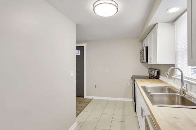681 Stewart Ave, Columbus, OH 43206 - kitchen with a sink, light countertops, appliances with stainless steel finishes, and white cabinets