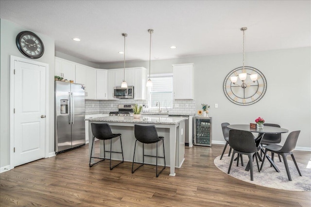 kitchen featuring a sink, appliances with stainless steel finishes, beverage cooler, and dark wood-style flooring