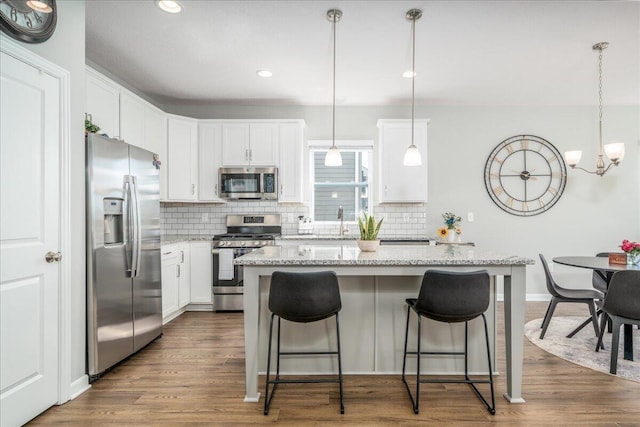 kitchen featuring tasteful backsplash, dark wood-type flooring, appliances with stainless steel finishes, and white cabinets