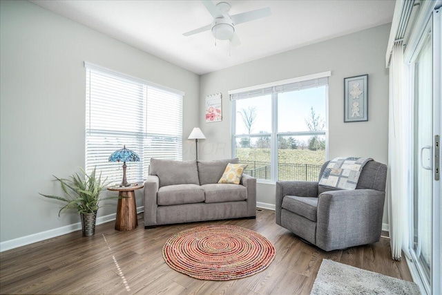 sitting room featuring wood finished floors, baseboards, and ceiling fan