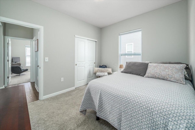 carpeted bedroom featuring a closet and baseboards