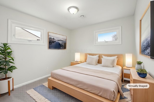 bedroom with baseboards and light colored carpet