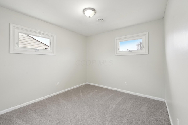 empty room featuring carpet flooring and baseboards