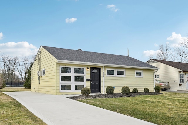 ranch-style house with a front lawn, driveway, and roof with shingles