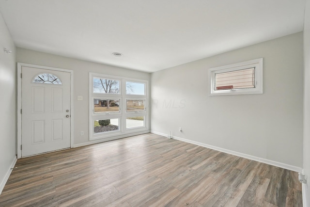 foyer entrance featuring visible vents, baseboards, and wood finished floors