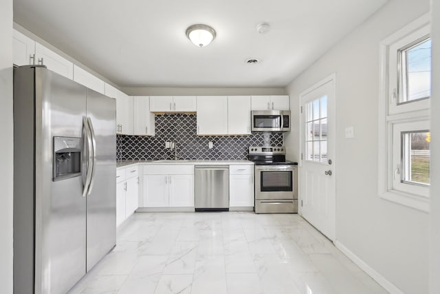 kitchen with tasteful backsplash, marble finish floor, appliances with stainless steel finishes, and a sink