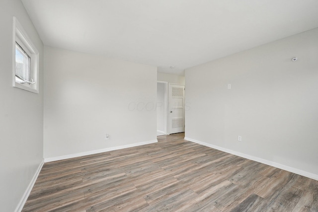 empty room with baseboards and wood finished floors