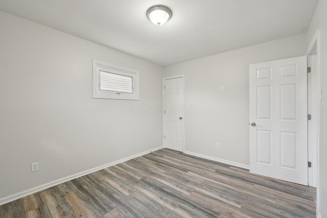 empty room featuring wood finished floors and baseboards