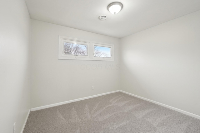 carpeted spare room with visible vents and baseboards