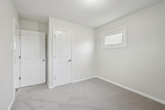 unfurnished bedroom with baseboards and carpet