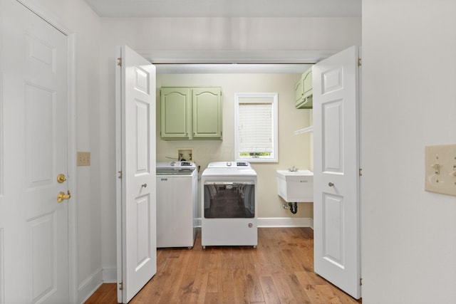 1299 Stratford Woods Dr, Newark, OH 43055 - laundry area featuring cabinet space, independent washer and dryer, light wood-style floors, and baseboards