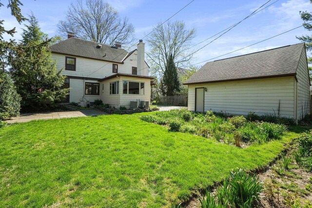 rear view of house with fence, a yard, and a patio