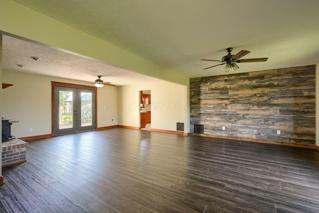 7704 Old Tarlton Pike, Circleville, OH 43113 - unfurnished living room featuring a ceiling fan, a wood stove, baseboards, dark wood-style flooring, and a textured ceiling