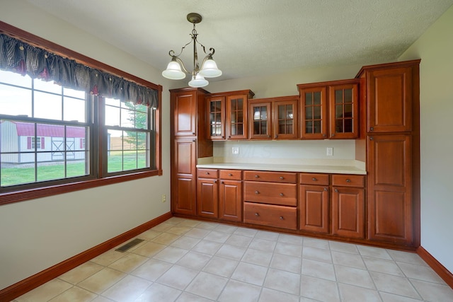 7704 Old Tarlton Pike, Circleville, OH 43113 - kitchen featuring light countertops, baseboards, pendant lighting, a chandelier, and glass insert cabinets