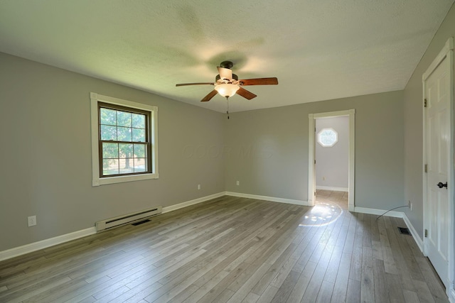 7704 Old Tarlton Pike, Circleville, OH 43113 - empty room with a baseboard radiator, ceiling fan, wood finished floors, a textured ceiling, and baseboards