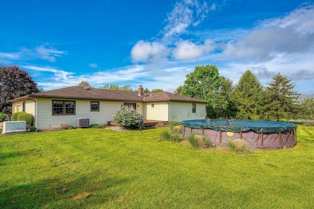 7704 Old Tarlton Pike, Circleville, OH 43113 - back of property with central air condition unit, a yard, a covered pool, and a chimney
