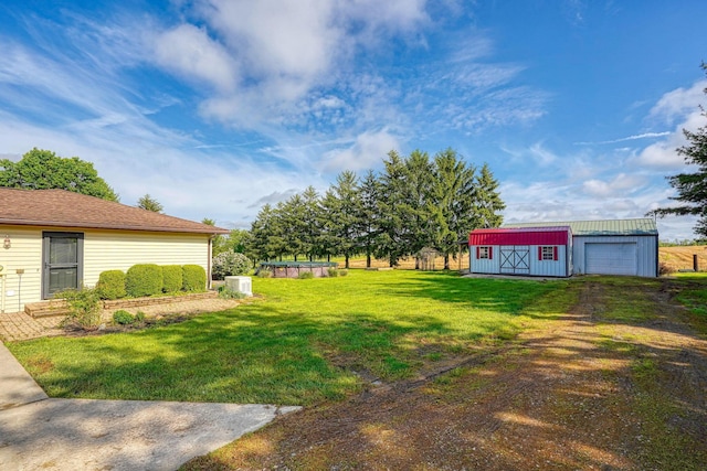 7704 Old Tarlton Pike, Circleville, OH 43113 - view of green lawn with an outbuilding, a detached garage, and driveway