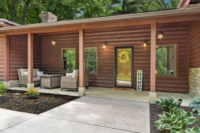 1001 Eckard Rd, Centerburg, OH 43011 - entrance to property featuring an outdoor hangout area, a chimney, log veneer siding, and a patio area