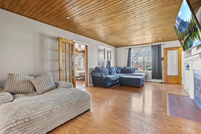living room with baseboards, wooden ceiling, and wood finished floors