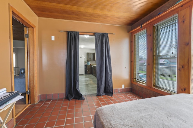 bedroom featuring baseboards, tile patterned flooring, wood ceiling, and freestanding refrigerator