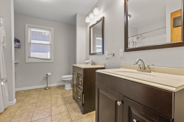 bathroom featuring tile patterned floors, two vanities, a sink, and baseboards