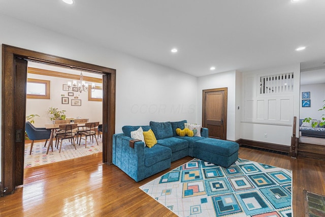 living room featuring baseboards, an inviting chandelier, recessed lighting, and wood finished floors