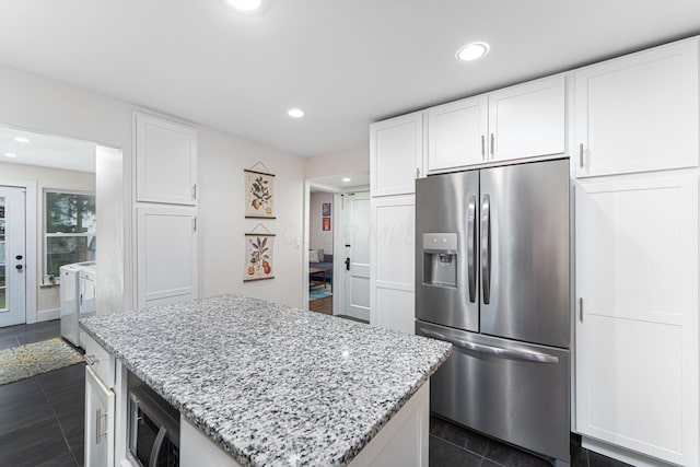 kitchen with stainless steel appliances, a center island, independent washer and dryer, and recessed lighting