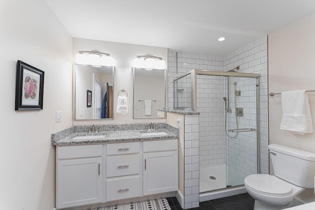 bathroom with a shower stall, toilet, a sink, and double vanity