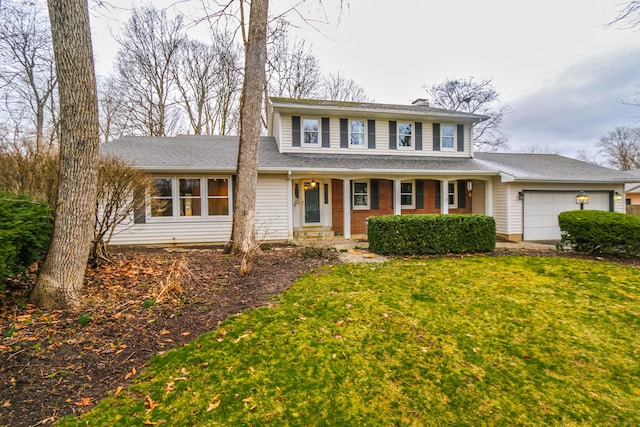 traditional-style house featuring a front lawn, brick siding, and a garage