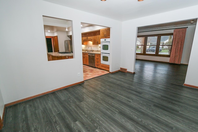 unfurnished living room featuring baseboards and wood finished floors