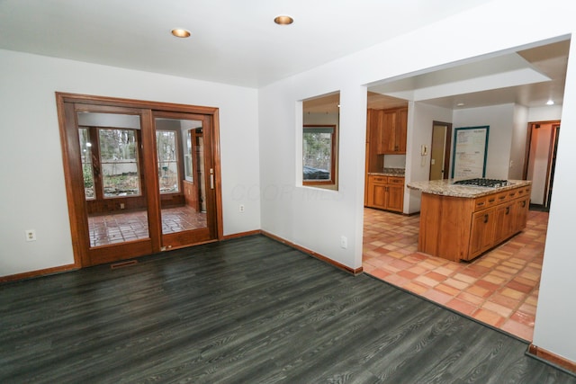 kitchen featuring baseboards, brown cabinets, light wood-style floors, and a healthy amount of sunlight