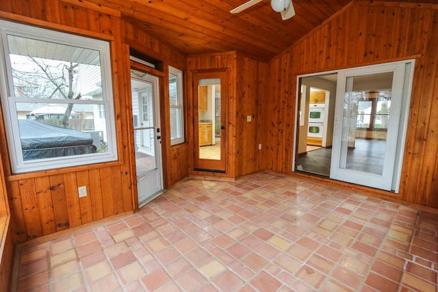 doorway to outside featuring ceiling fan, lofted ceiling, wood ceiling, and wood walls