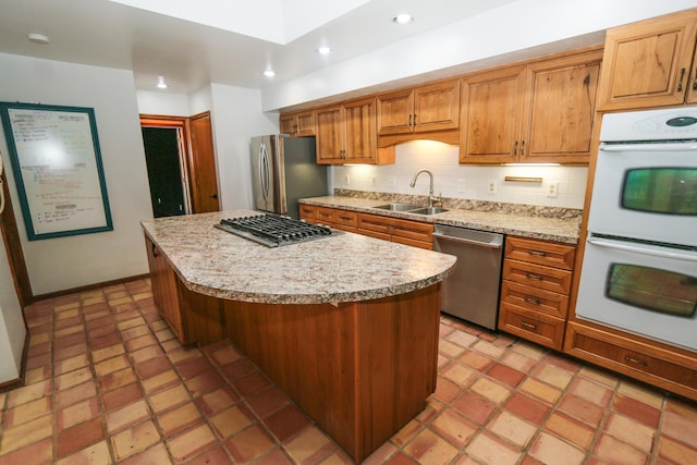 kitchen with recessed lighting, a sink, stainless steel appliances, tasteful backsplash, and a center island