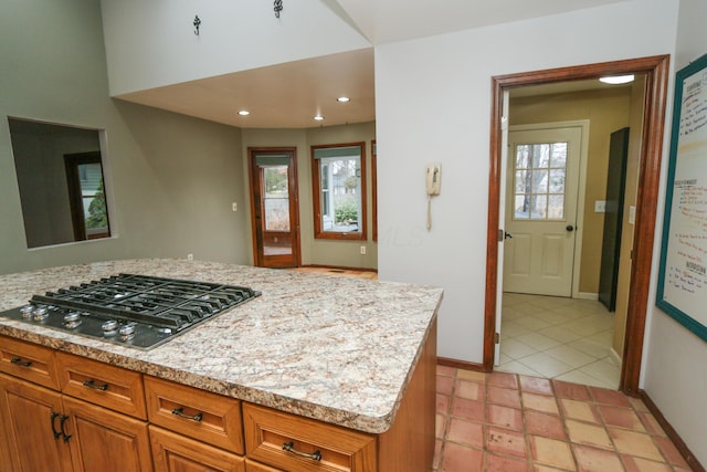 kitchen with brown cabinetry, recessed lighting, gas stovetop, and baseboards