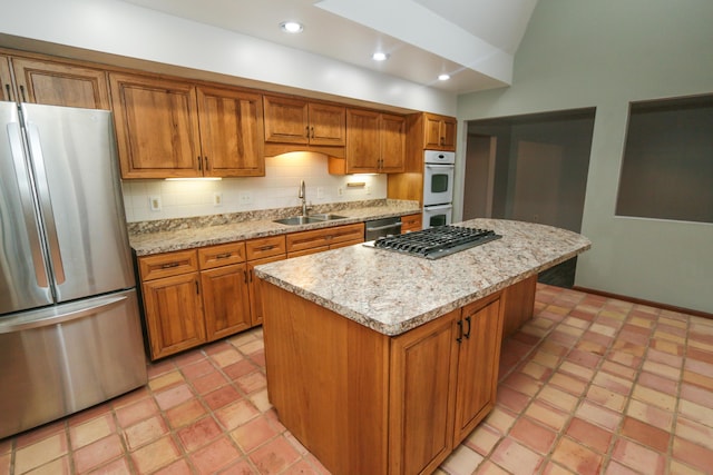 kitchen with a sink, brown cabinets, tasteful backsplash, and appliances with stainless steel finishes